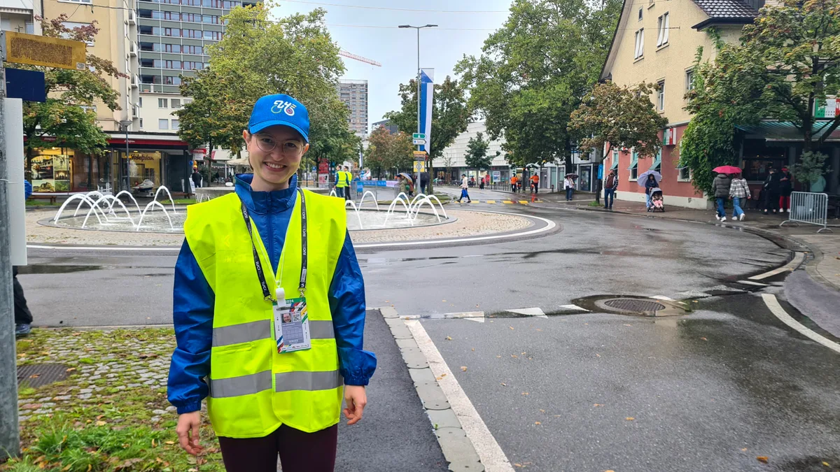 Anik Bachmann sorgt dafür, dass die Rennstrecke immer frei bleibt. Fussgänger und Velofahrer dürfen die Strecke nur mit ihrer Zustimmung überqueren. Eine Frau in gelber Weste vor einem Kreisel in Uster.